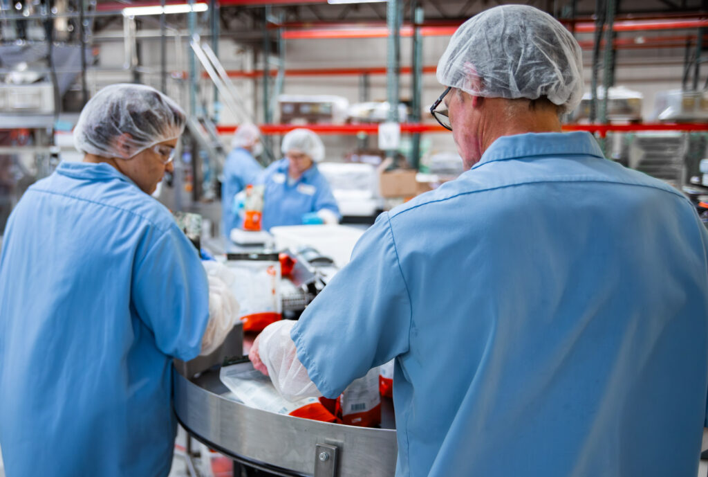 two team members inspecting and managing packaging line